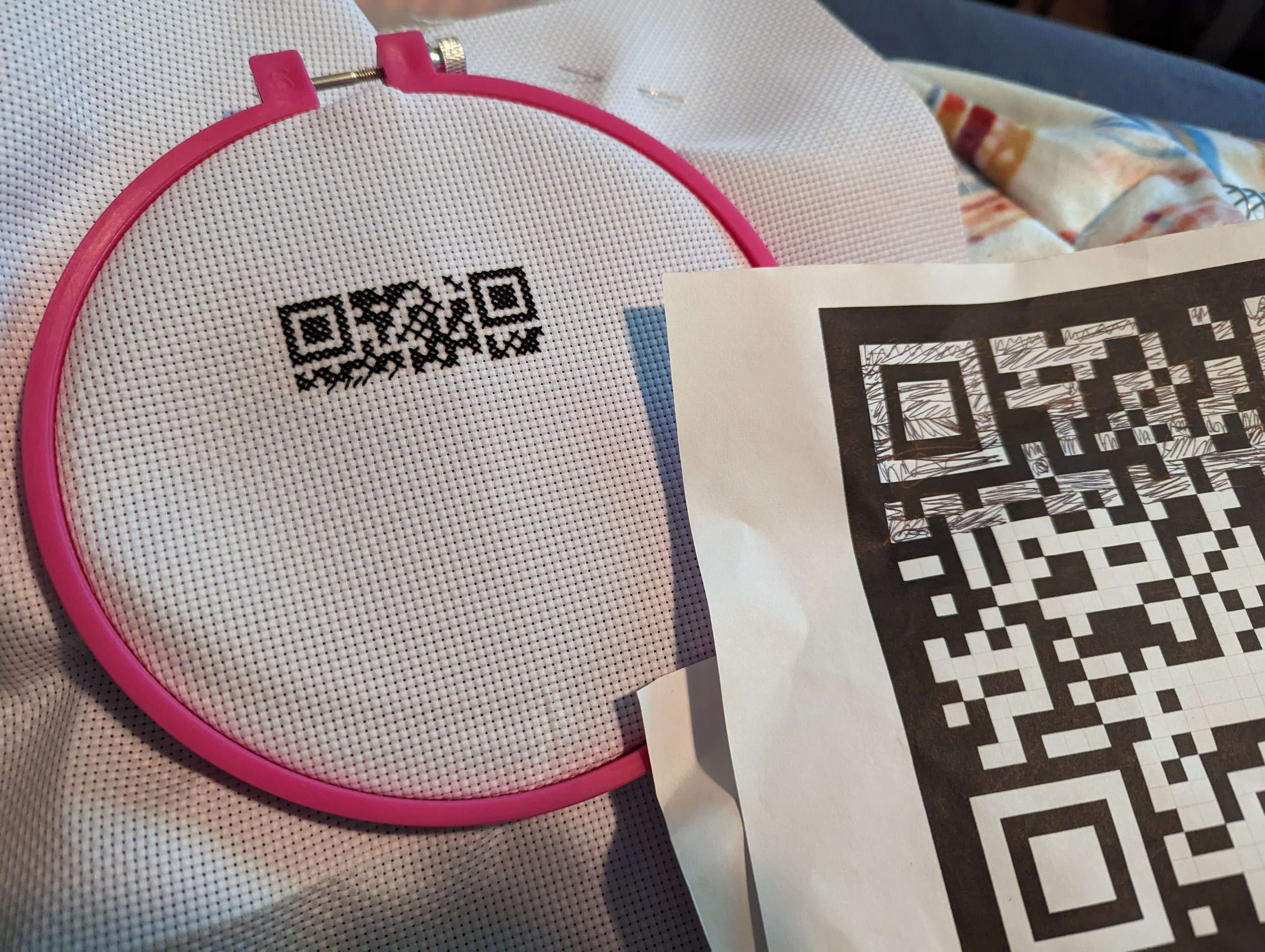 QR cross-stitch in progress, plus the pattern it comes from, partially marked off